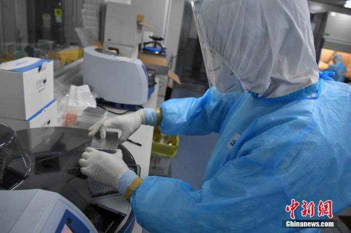 6月26日凌晨，检测人员使用离心机进行核酸提取工作。为应对北京核酸检测工作，北京金域医学实验室在端午节成立多个班次，昼夜轮替加速处理来自朝阳区的大规模街道社区筛查样本。班次中，有10名检验员是此前曾参与过武汉、广州、吉林、黑龙江等地抗疫的“老兵”。另据介绍，该实验室团队目前已配备超过100人的专业团队、几十台PCR扩增仪，日核酸检测产能可达约3万例。
中新社记者 崔楠 摄