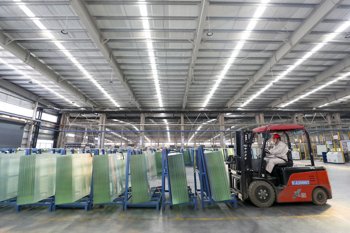1月28日，湖南资兴经济开发区一家公司的工人在光伏组件高透基板材料生产车间忙碌。新华社发(李科 摄)